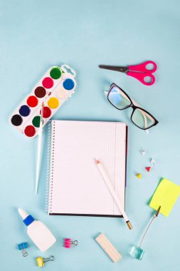 Egzersiz kitabı ofisi ya da okul malzemeleri mavi arka planda, düz yerde. Okula geri dön.