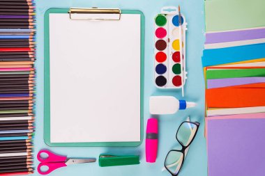 Pano ve ofis veya okul malzemeleri mavi arka plan üzerinde, düz yatıyordu. Okula geri dön