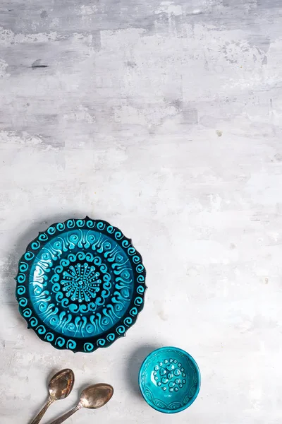 トルコの陶磁器は、石の背景にスプーンで青いプレートとボウルを飾りました, トップビュー — ストック写真