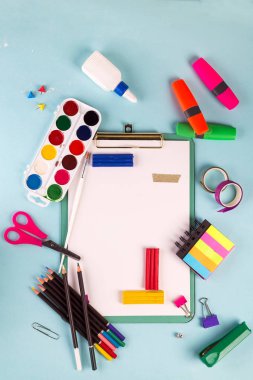 Pano ve ofis veya okul malzemeleri mavi arka plan üzerinde, düz yatıyordu. Okula geri dön