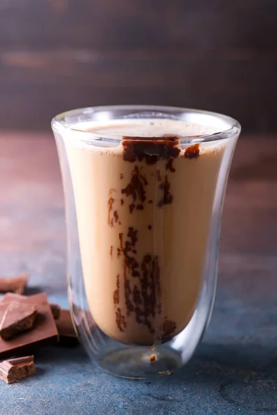 透明的双层玻璃杯，加拿铁咖啡和黑石质背景的巧克力 — 图库照片