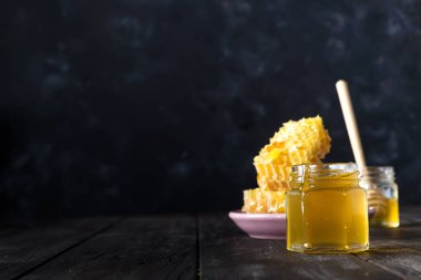 Kopya alanı ile karanlık masada lezzetli bal ve taze petek