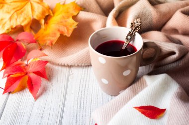 Ahşap arka planda sonbahar yaprakları ile kırmızı çay, sonbaharda ev yapımı içecek. Kopyalama alanı