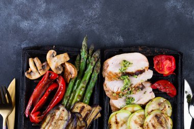 Beton bir arka plan üzerinde dökme demir tavada barbekü sebze ve pesto sos ile Tavuk göğsü ızgara, düz yatıyordu,