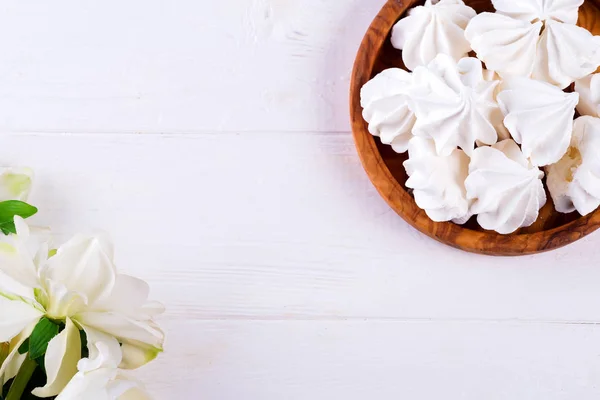 Homemade white meringue in wooden plate on white wooden background, flat lay — Stock Photo, Image