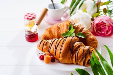 Beyaz ahşap arka planda kahvaltı - kruvasan, reçel, çilek ve kahve