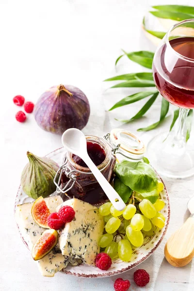 Surtido de quesos, bayas y uvas con vino tinto en vasos sobre fondo de piedra. Copiar espacio —  Fotos de Stock