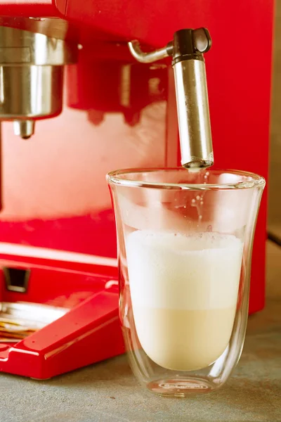 Rote Kaffeemaschine im Retro-Stil und Latte-Glas mit geschlagener Milch aus nächster Nähe — Stockfoto