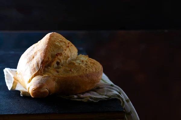 Pan francés casero con una servilleta sobre un fondo oscuro, espacio para copiar —  Fotos de Stock