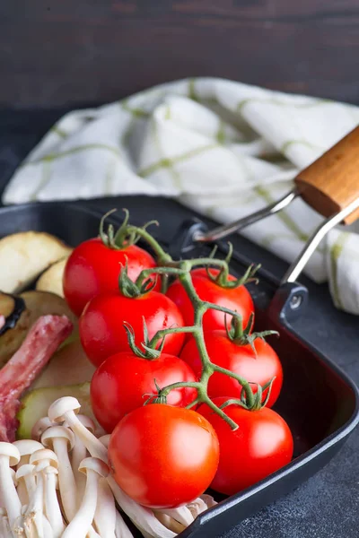 Tortiera di pomodorini freschi come ingredienti di cottura per piatto su sfondo scuro con tovagliolo — Foto Stock