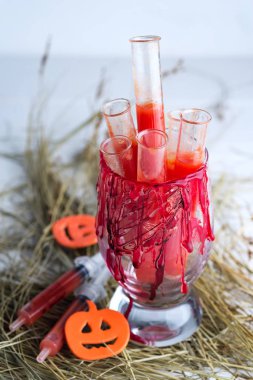 Domates suyu test tüpleri ile Halloween kanlı cam . Kuru ot üzerinde parti içecekler