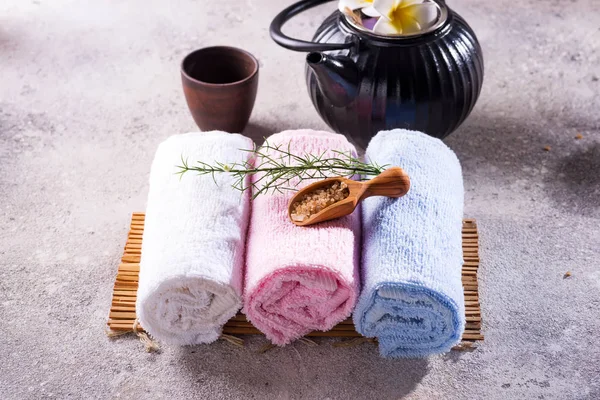 Asciugamani di colore con foglie verdi, cucchiaio di sale e tè disintossicante su tappetino di bambù e tavolo di pietra — Foto Stock