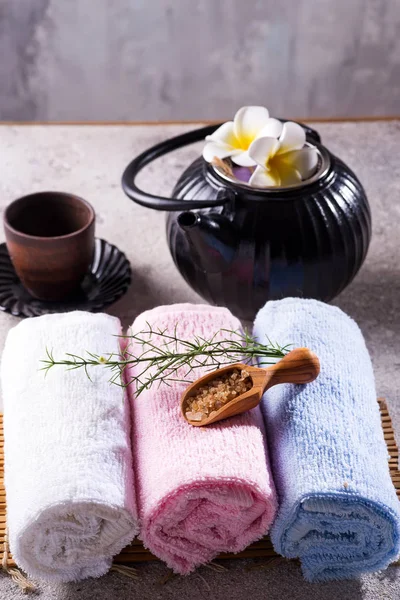 Asciugamani di colore con foglie verdi, cucchiaio di sale e tè disintossicante su tappetino di bambù e tavolo di pietra — Foto Stock