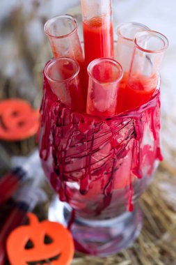 Domates suyu test tüpleri ile Halloween kanlı cam . Kuru ot üzerinde parti içecekler