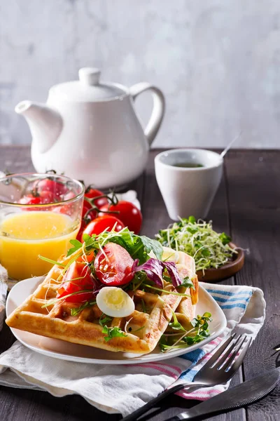 Waffles belgas com abacate, ovos, micro verde e tomates com suco de laranja e chá em mesa de madeira. Pequeno-almoço perfeito para alimentos saudáveis ou perder peso. Sanduíche de abacate . — Fotografia de Stock