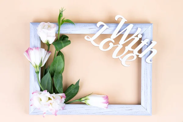 빈 흰색 프레임, 사랑의 단어와 꽃 eustoma 와 함께 복사 공간 이 있는 베이지 종이 배경. 축일 개념 — 스톡 사진