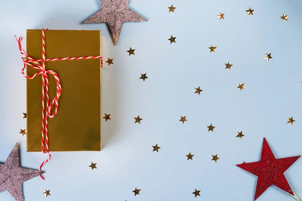 크리스마스 패턴은 황금색, 은색, 빨간색 별들로 만들어 졌고 파란 배경에 황금 선물 상자가 있습니다. 겨울 개념. 편평 한 침대. — 스톡 사진
