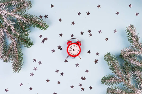 Ceas roșu de epocă, spruci de brad și stele decorative pe fundal albastru. Conceptul sărbătorilor de iarnă . — Fotografie, imagine de stoc