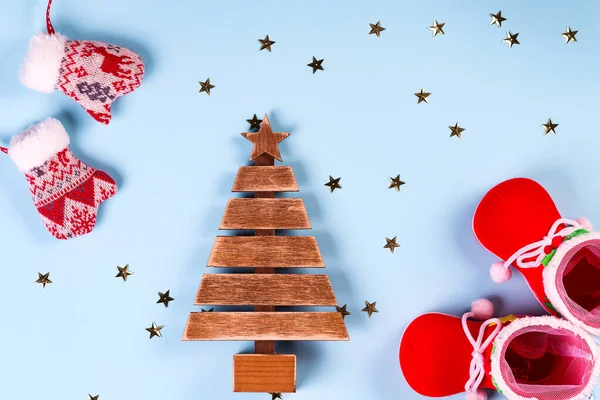 Roupas de Papai Noel com sapatos e luvas em um fundo azul, abeto de madeira com estrelas no fundo, vista superior — Fotografia de Stock