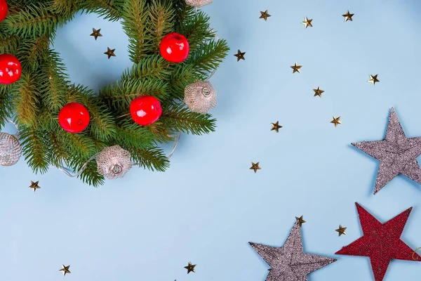 淡淡的圣诞花环，蓝纸背对着装饰和大明星玩具，平平的躺着 — 图库照片