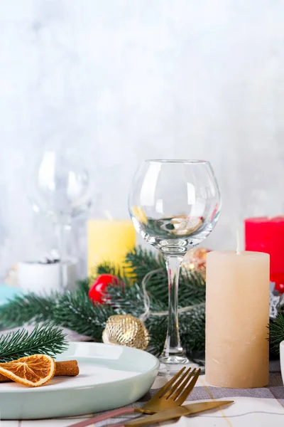 Ünnepi karácsonyi és újévi asztali díszlet száraz naranccsal és fahéjjal szürke textilen. Fenyőtobozokkal, ágakkal és gyertyákkal díszített étkezőhely — Stock Fotó