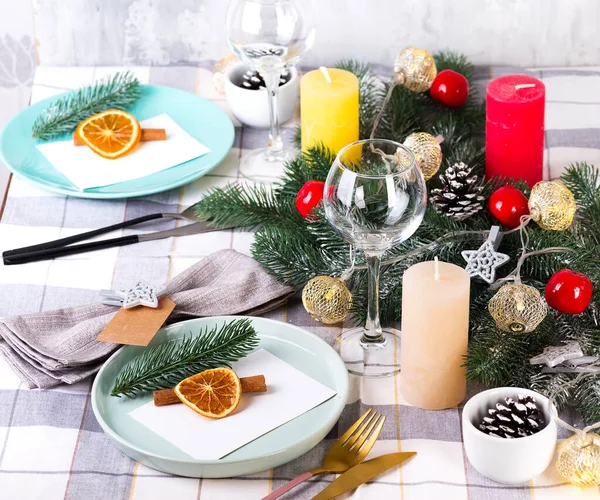 Fiestas de Navidad y Año Nuevo ajuste de mesa con naranja seca y canela en un textil gris. Comedor decorado con conos de pino, ramas y velas —  Fotos de Stock