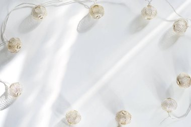 Beyaz arka planda güneş ışınları olan Noel ışık topları. Düz metin kopyalama alanı