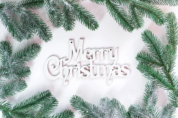 Letras de madeira Feliz Natal com ramos de abeto e neve em um fundo branco. Cartão de Natal. Depósito plano — Fotografia de Stock