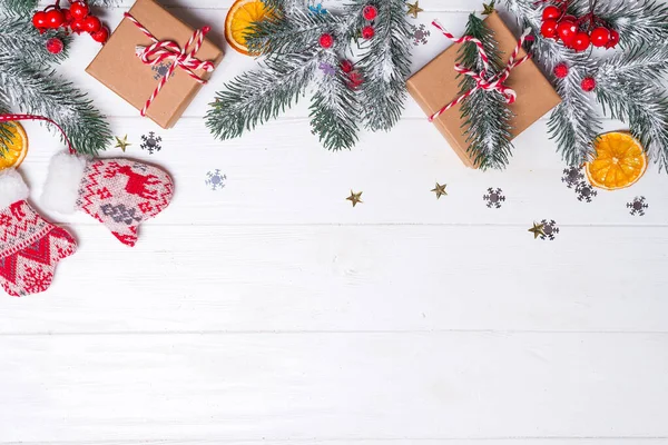 Cajas de regalo con ramas de abeto de nieve y decoración de juguetes sobre un fondo de madera blanca. Tarjeta de Navidad. Espacio plano de copia lay — Foto de Stock
