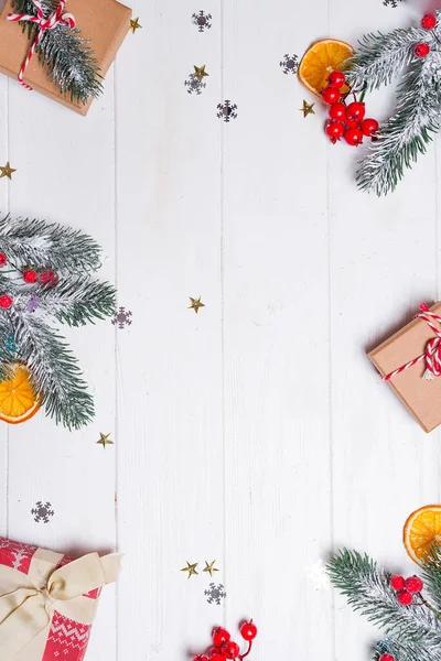 Cajas de regalo con ramas de abeto de nieve y decoración de juguetes sobre un fondo de madera blanca. Tarjeta de Navidad. Espacio plano de copia lay — Foto de Stock