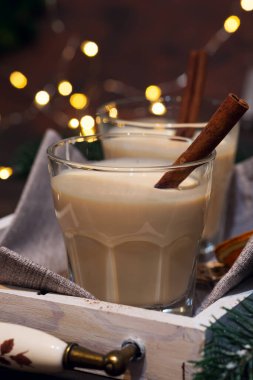 Koyu arkaplanda Tarçın Çubuğu ve açık renkli ev yapımı Beyaz Tatil Yumurtası. Noel içeceği