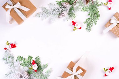 Noel ve Yeni Yıl bayramı kompozisyonu. Çerçeveyi köknar dalları, hediye kutusu, kurdeleler ve beyaz arka planda Noel Baba ile süsleyin. Düz konum, üst manzara şenlik konsepti.