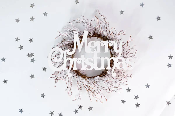 Bokstäver God Jul och krans grenar av frost på vit bakgrund med solljus strålar och stjärnor, platt låg kopia utrymme — Stockfoto