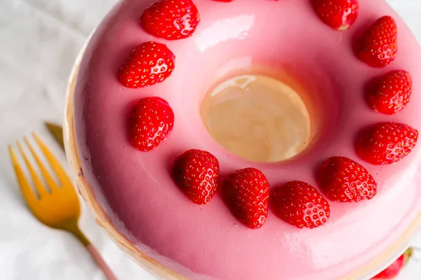 Frisch zubereitete hausgemachte Früchte glasiert rosa Dessert dekorierte Erdbeeren auf einer Glasschale vor hellgrauem Hintergrund. — Stockfoto