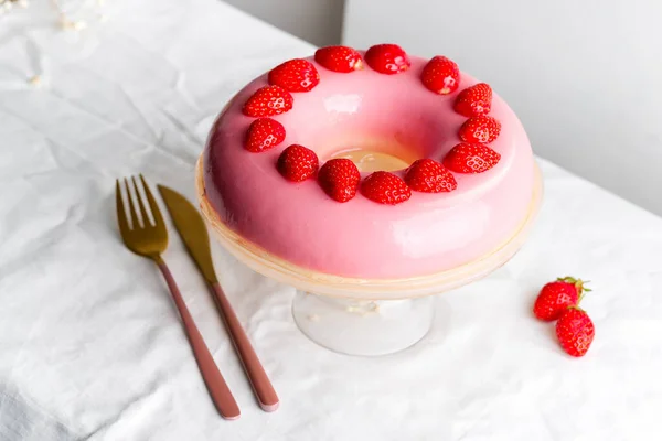 Φρεσκοπαρασκευασμένα σπιτικά φρούτα τζάμια ροζ επιδόρπιο διακοσμημένα φράουλες σε ένα γυάλινο πιάτο με ανοιχτό γκρι φόντο. — Φωτογραφία Αρχείου