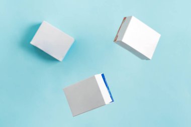 Açık mavi arkaplan üzerinde doğal ürünler ve ürünler paketlemek için uçan el sanatları sahte kağıt kutular. Üst görünüm.