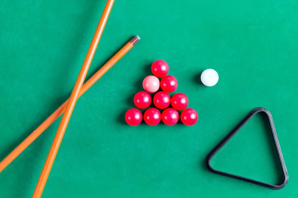 Billiard colorful balls with wooden cue on green table. Snooker, Pool game. Top view.