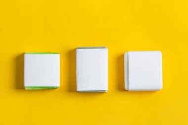 Sarı arka planda kağıt etiketli el yapımı bitkisel sabun seti. Tasarımınız ve yaratıcılığınız için bir model.