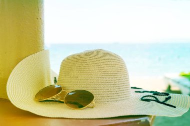 Güneş şapkası ve güneş gözlüğüyle bir rafta..