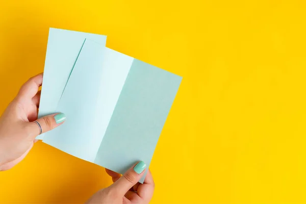 Dois folhetos de papel mockup verde em uma mão de mulheres. — Fotografia de Stock