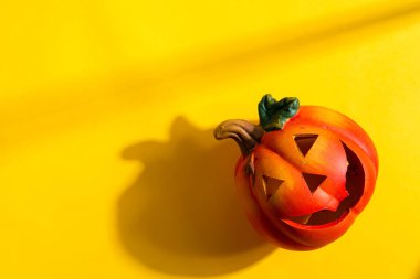 Cadılar bayramı partisi için balkabağı feneriyle dekorasyon ve el yapımı yarasalar, sarı arka planda kedi ve örümcek gölgeleri, kopyalama alanı.