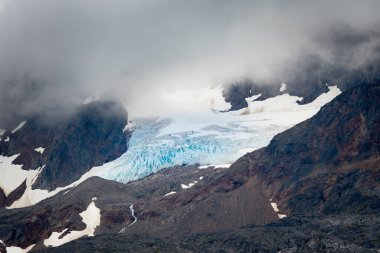 Skagway yakınlarındaki bir dağın zirvesinde sisle kaplanmış büyük mavi buzdağı, AK