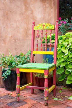 Colorful old chair sitting outside on Canyon Road in Santa Fe, NM clipart