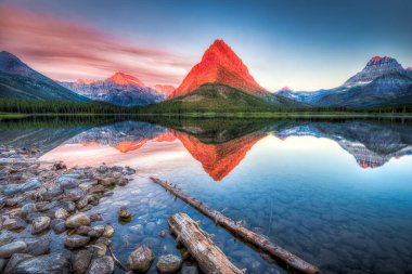 Stunning reflections on Swiftcurrent Lake in northern Montana at sunrise clipart