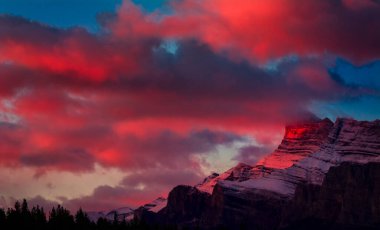 Kırmızı şafak ışığı Banff, Kanada 'nın dışındaki sivri tepeleri yakalıyor.
