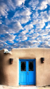 Unique blue door and a dramatic sky in Santa Fe, NM clipart