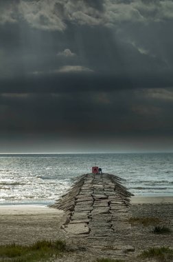 Galveston 'da taş bir iskelede balıkçı, bulutlu bir sabahta TX