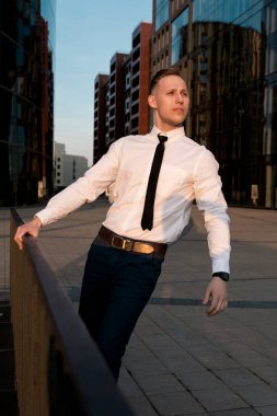 İşadamı dışarıda, gün batımını izliyor