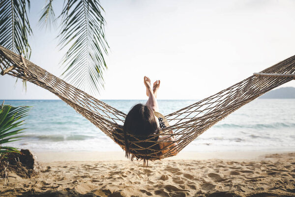 Happy woman relaxing in hammock