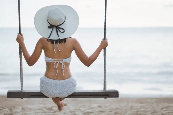 Vrouw op schommel in strand — Stockfoto